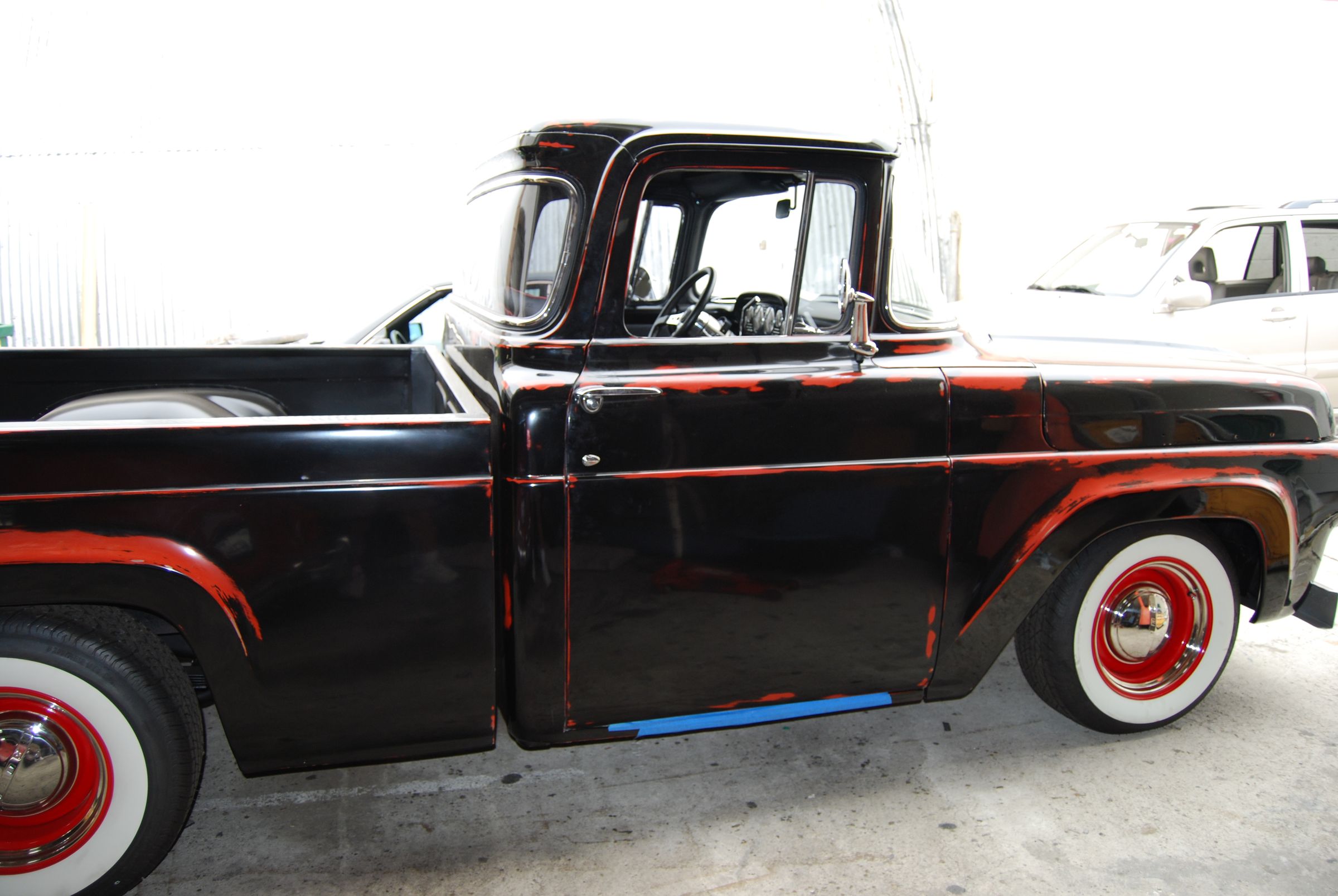 1950s Ford pickup in black with red wheels